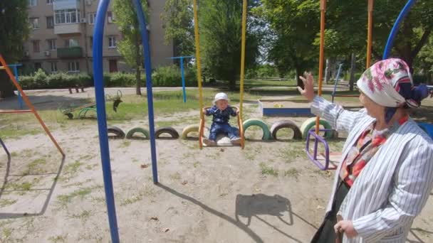 Abuela con un nieto en un columpio — Vídeos de Stock