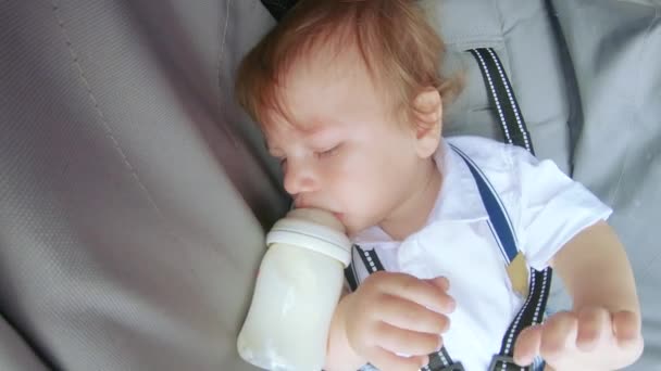 Baby in een kinderwagen eet — Stockvideo