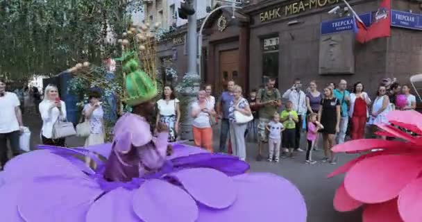 Tänzer auf Stelzen in Anzügen mit bunten großen Blumen — Stockvideo