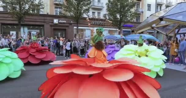 Dansare på styltor i dräkter av färgglada stora blommor — Stockvideo