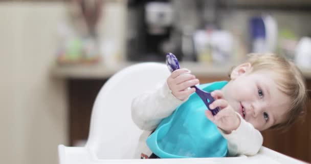 Дитячий хлопчик їсть з ложкою — стокове відео