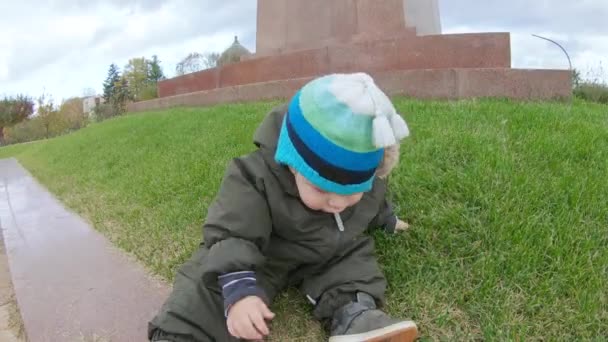 Niño toca hierba cortada — Vídeos de Stock