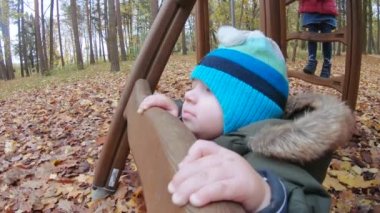 Küçük çocuk ahşap merdivenlerde duruyor.