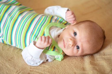 Lying on the bed sheet baby at home