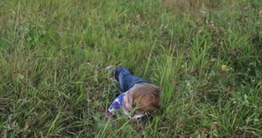 Yoğun çimlere düşen küçük bir çocuk.