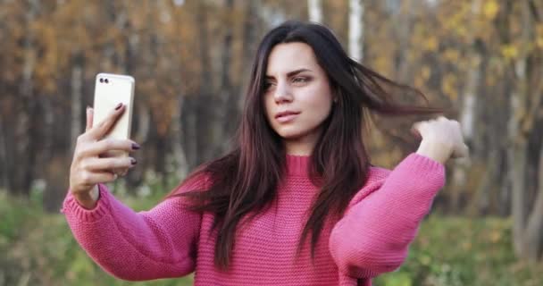 Una ragazza con un maglione rosso prende — Video Stock