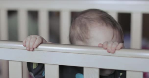 Мальчик в детской кроватке — стоковое видео