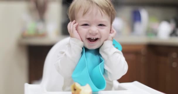 Spädbarn pojke sitter och håller i öron — Stockvideo