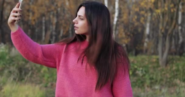 Uma menina com uma camisola vermelha leva — Vídeo de Stock
