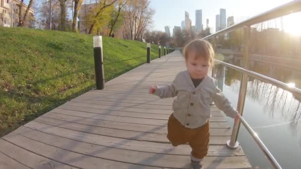 Barnpojken springer på en träplattform — Stockvideo