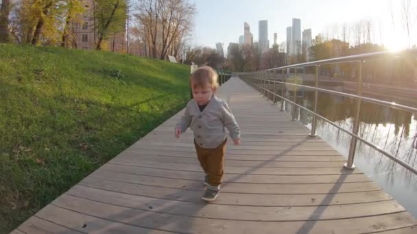 Chłopiec biegnie na drewnianej platformie. — Wideo stockowe