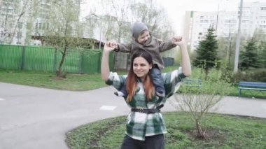 Annesinde paltolu bir çocuk var.