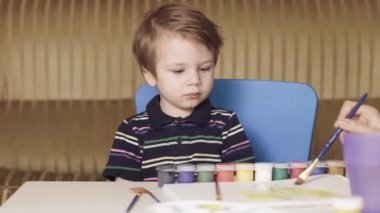 Annem bir çocuğa resim yapmayı öğretiyor.