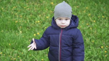 Çocuk ön bahçede yürüyor.