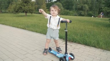 Çocuk scooter sürmeyi öğreniyor.