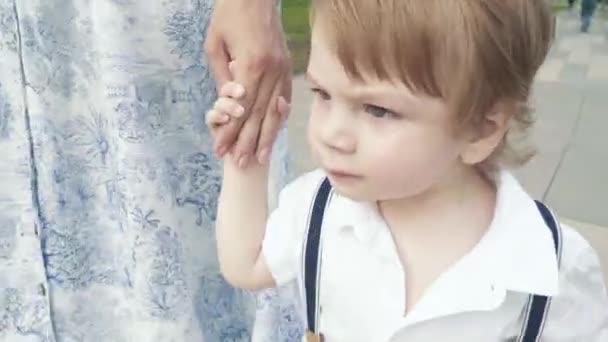 A boy walks hand with mom — Stock Video