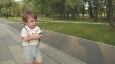 Anne oğluna scooter sürmeyi öğretiyor.