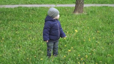 Çocuk ön bahçede yürüyor.
