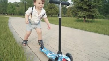 Çocuk scooter sürmeyi öğreniyor.