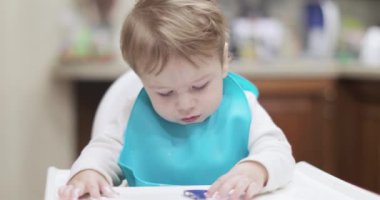 Bebek kaşıkla yemek yiyor.