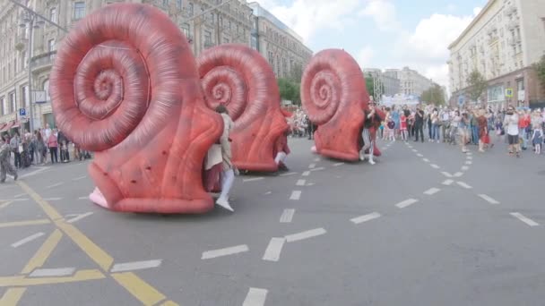 Animadores com fantoches em tamanho real na forma de enormes caracóis vermelhos com conchas — Vídeo de Stock