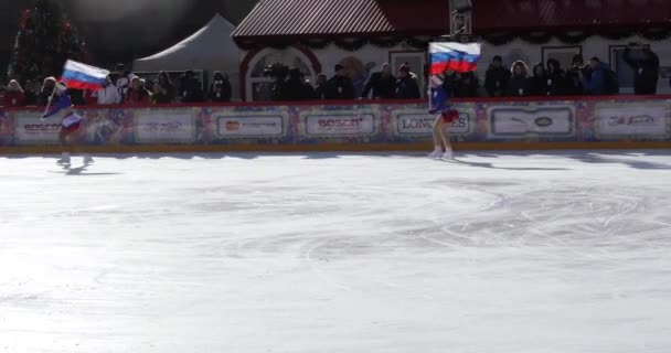 Patinaje artístico con la bandera de Rusia en la pista de hielo en la Plaza Roja — Vídeo de stock