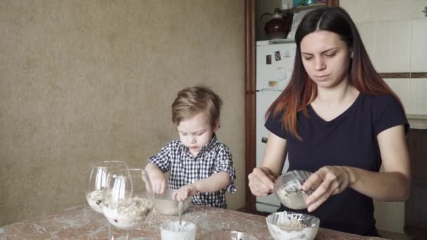 Oğlan çocuğu anneye hazırlıkta yardım ediyor. — Stok video