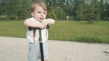 Çocuk scooter sürmeyi öğreniyor.