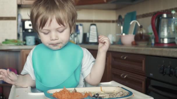 Мальчик ест яйца и морковь — стоковое видео