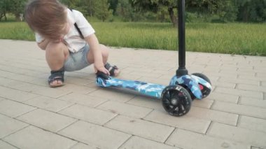 Çocuk scooter sürmeyi öğreniyor.