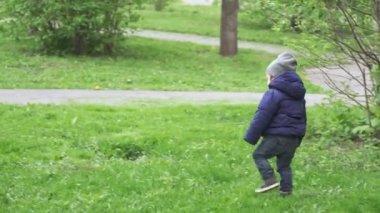 Çocuk sokakta yürüyor.