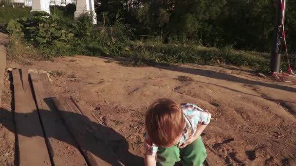 Um menino brinca com areia — Vídeo de Stock