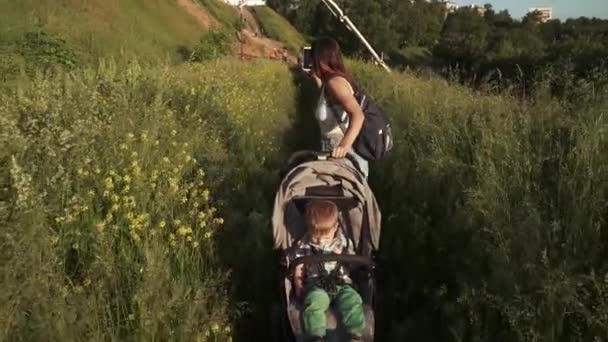 Pojke med mamma i barnvagn — Stockvideo