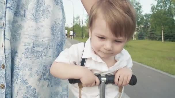 Mutter lehrt sohn bis reiten ein roller — Stockvideo