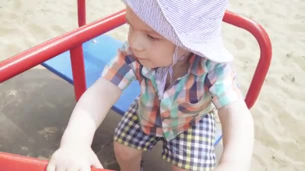 A fiú körhintán ül. — Stock videók