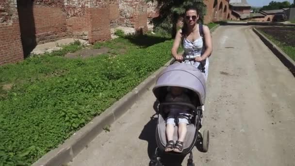 A boy in a stroller on a step — Stock Video