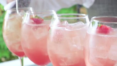 Barmen alkol ve çilek doldurur.