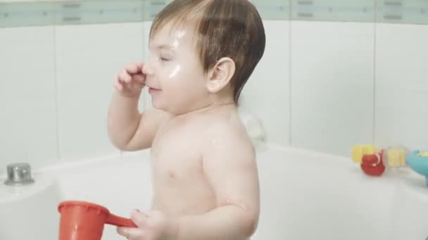 Малыш в ванной пьет — стоковое видео