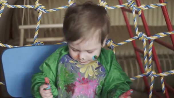 Niño en la mesa con pintura — Vídeos de Stock