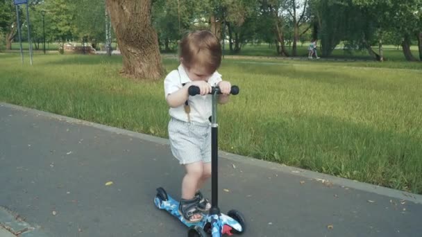 Çocuk scooter sürmeyi öğreniyor. — Stok video