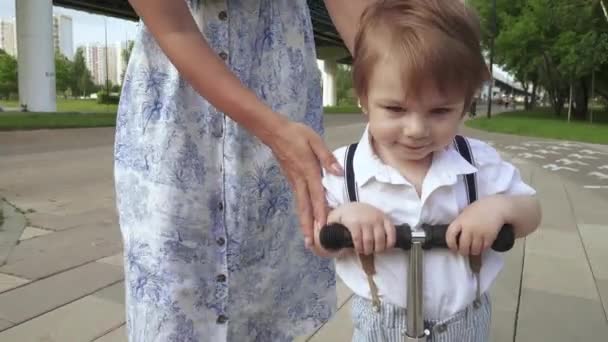 Мама вчить сина їздити на скутері. — стокове відео