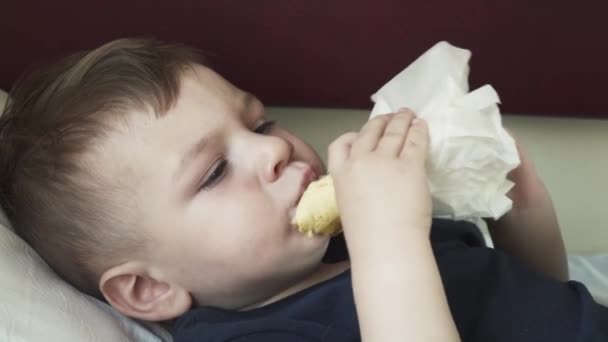 Хлопчик їсть шаурму на полиці машини — стокове відео