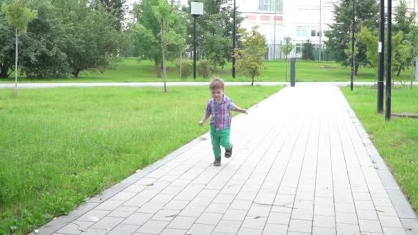 Мальчик бежит по улице — стоковое видео
