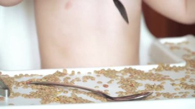 Bezelye ve fasulyelerle oynayan çocuk.