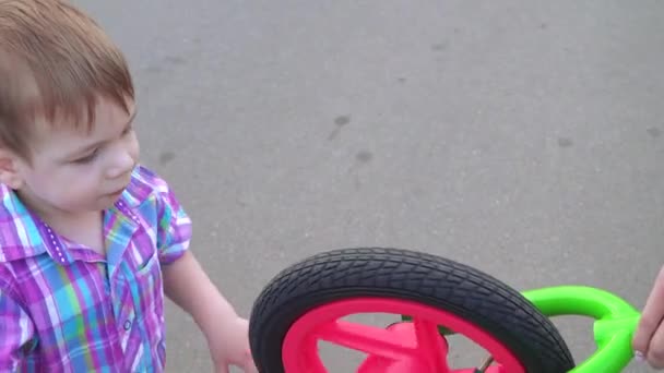 Jongen draaiende loopfiets wiel — Stockvideo