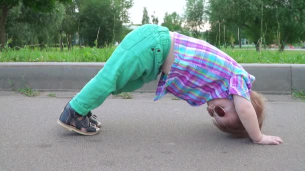 Chłopiec w okularach robi jogę asana — Wideo stockowe