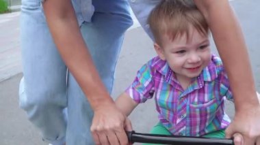 Anne oğluna ata binmeyi öğretiyor.