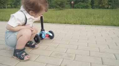 Çocuk scooter sürmeyi öğreniyor.