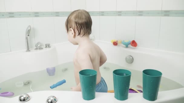 Bébé garçon dans la salle de bain boissons — Video