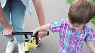 Anne oğluna ata binmeyi öğretiyor.